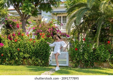 Woman Front Behind Of A Woman Walking Along The River Of A Luxury House With Beautiful Landscaping On A Bright, Sunny Day, Modern Design.