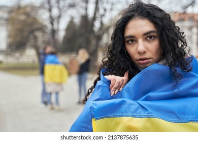 Woman in front of group of young caucasian people manifesting against war in Ukraine - Shutterstock ID 2137875635