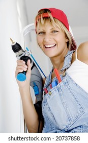 Woman In Front Of Ladder With Power Tool And A Range Of Tools In Her Pocket