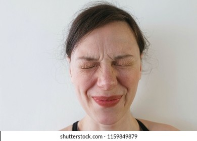 Woman frowns from sour taste. Close-up face.