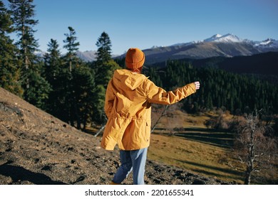 Woman Full Back Hiker Running On The Mountain Looking At Nature Happiness Overlooking Snowy Mountains And Trees In Yellow Raincoat Travel And Hiking In The Mountains At Sunset Freedom