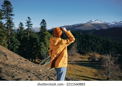 Woman Full Back Hiker Running On The Mountain Looking At Nature Happiness Overlooking Snowy Mountains And Trees In Yellow Raincoat Travel And Hiking In The Mountains At Sunset Freedom