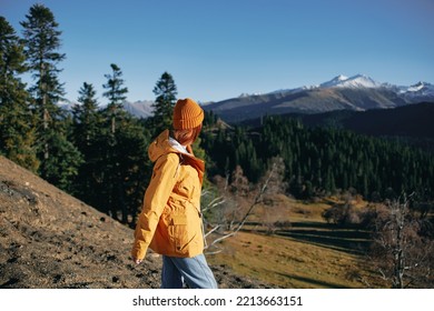 Woman Full Back Hiker Running On The Mountain Looking At Nature Happiness Overlooking Snowy Mountains And Trees In Yellow Raincoat Travel And Hiking In The Mountains At Sunset Freedom