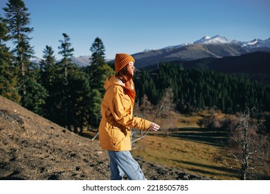 Woman Full Back Hiker Running On The Mountain Looking At Nature Happiness Overlooking Snowy Mountains And Trees In Yellow Raincoat Travel And Hiking In The Mountains At Sunset Freedom