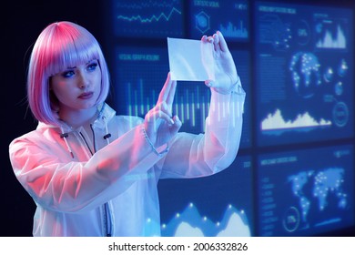 Woman with futuristic tablet in hand. Girl in glasses of virtual reality presses the start button. Augmented reality game, future technology, AI concept. Holographic interface to display data. - Powered by Shutterstock