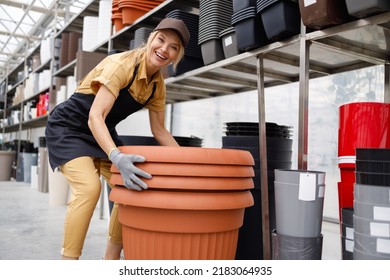 Woman Garden Center Worker Carrying Large Pots