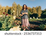 Woman gardener embracing the beauty of nature on her sustainable homestead. Plant lover in her element: enjoying the beauty of nature and sustainability on her land