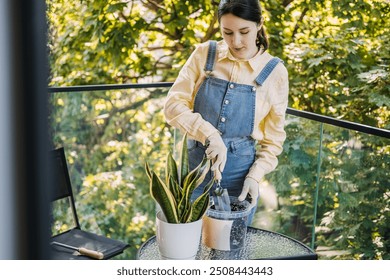 Woman gardening on balcony, planting houseplant in pot, urban gardening, self-care, nature connection, balcony gardening, sustainable living. - Powered by Shutterstock