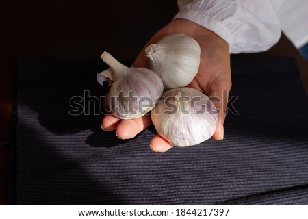 Woman with garlic head in her hands, vegan food, seitan.