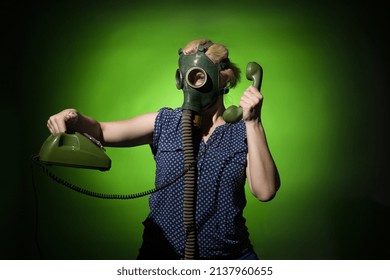 A Woman In A Gas Mask Calls On A Retro Phone On A Dark Dramatic Background, Hard Light