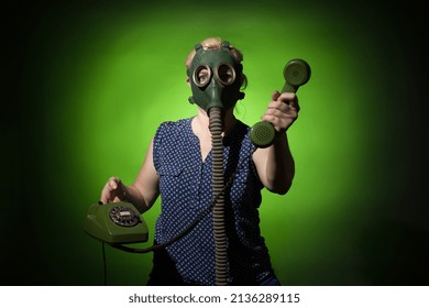 A Woman In A Gas Mask Gives Up A Retro Phone On A Dark Dramatic Background, Hard Light.