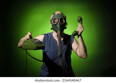 Woman In A Gas Mask Talking On A Retro Phone On A Dark Dramatic Background, Hard Light