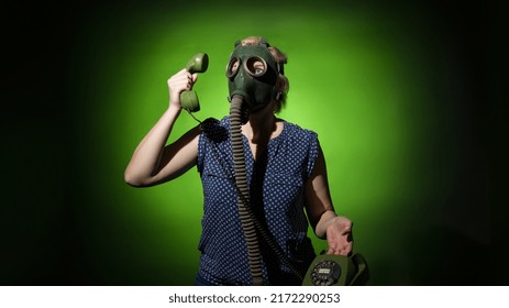 Woman In A Gas Mask Talking On A Retro Phone On A Dark Dramatic Background, Hard Light