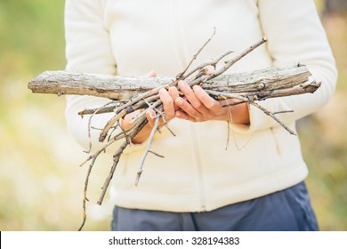 woman gathering wood for a fire - Powered by Shutterstock