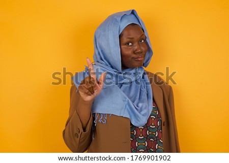 Woman gesturing a no sign. Closeup portrait unhappy, serious girl raising finger up saying: oh no you did not do that. Standing over yellow background. Negative emotions facial expressions, feelings.
