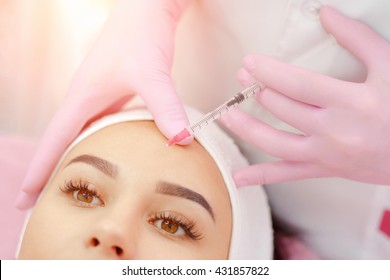 Woman gets injection in her face. Beauty woman giving botox injections. Young woman gets beauty facial injections in the cosmetology salon. Face aging injection. Aesthetic Medicine, Cosmetology
