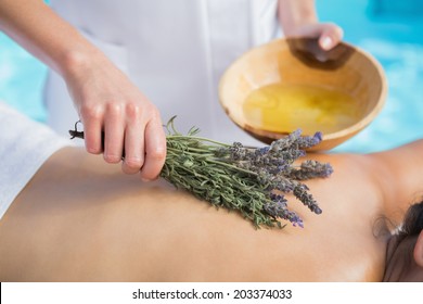 Woman getting an aromatherapy treatment poolside outside at the spa - Powered by Shutterstock