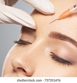 Woman Getting Cosmetic Injection Of Botox Near Eyes, Closup.Woman In Beauty Salon. Plastic Surgery Clinic.