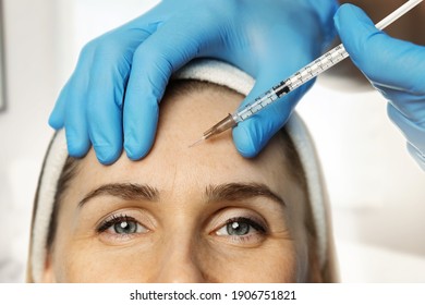 woman getting cosmetic injection in forehead to reduce wrinkles