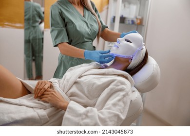 Woman Getting Cosmetic Procedure With LED Facial Mask. Photon Therapy.