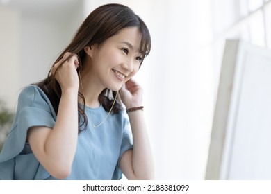 A Woman Getting Dressed In Front Of A Mirror