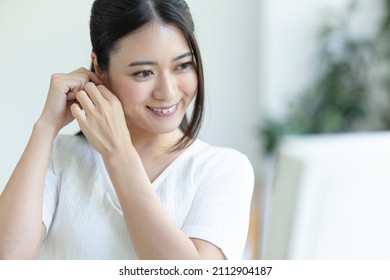 A Woman Getting Dressed Looking In The Mirror