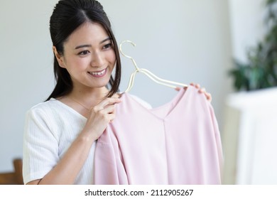 A Woman Getting Dressed Looking In The Mirror