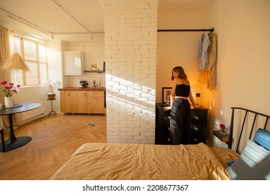 Woman Is Getting Dressed In Wardrobe Of Her Tiny And Stylish Studio Apartment. Interior Design And Domestic Lifestyle Conept