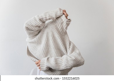 Woman Getting Dressed In A Wool Sweater