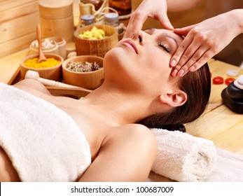 Woman Getting Facial  Massage In Wooden Spa.