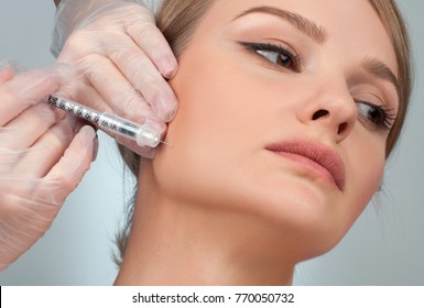 Woman Is Getting Filler Injection In Cheeks. Anti-aging Treatment And Face Lift. Cosmetic Treatment. Facial Skin Lifting Injection To Woman's Face. Plastic Surgery