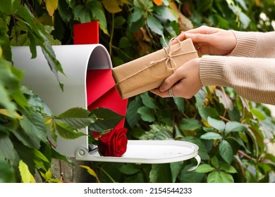 Woman Getting Gift From Mail Box Outdoors