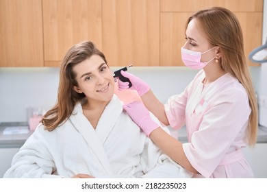 Woman Is Getting Her Earlobe Pierced With A Professional Machine