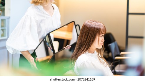 A Woman Getting Her Hair Cut At A Beauty Salon