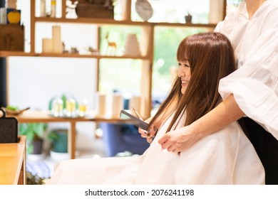 A Woman Getting Her Hair Cut At A Beauty Salon