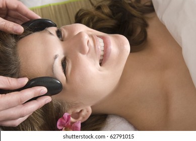 Woman Getting Hot Stone Facial At Spa.