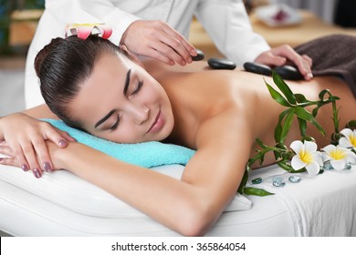 Woman getting a hot stone massage at spa salon