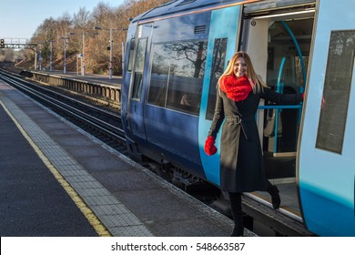 Woman Is Getting Off The Train On The Station, She Wears Red Scarf And Gloves. Main UK Railway Route To/from Central London