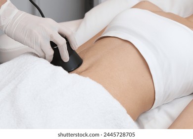 Woman getting a RF treatment in her abdomen for slimming radio frequency treatment