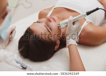Woman getting rf-lifting facial by professional cosmetician