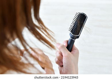 Woman getting shocked by hair loss - Shutterstock ID 2194123943