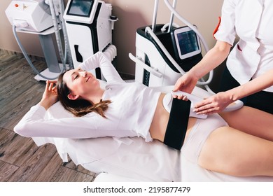 Woman getting treatment on abdomen to burn fat and build muscles, slimming technology - Shutterstock ID 2195877479