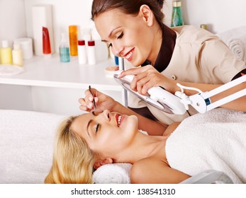 Woman getting tweezing eyebrow by beautician. - Powered by Shutterstock