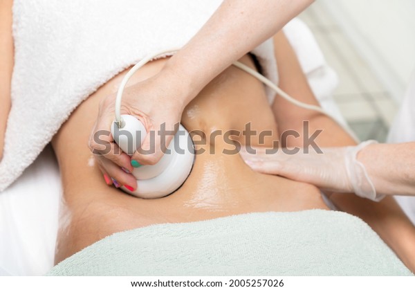 Woman getting ultrasound cavitation\
treatment by cosmetologist. female client enjoying anti-cellulite\
procedure at beauty salon. High quality\
photo