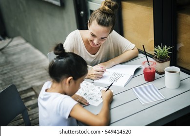 Woman And Girl Doing Homework Concept