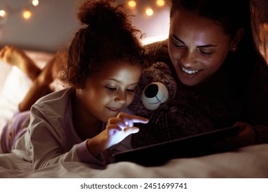 Woman, girl kid and tablet in bed, storytelling or watch cartoon at bed time with bonding and love at family home. Mother, daughter and together in bedroom at night with ebook, games or movie - Powered by Shutterstock