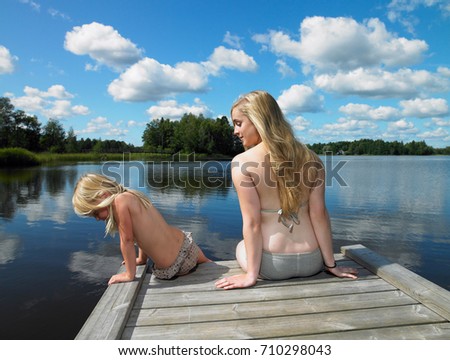 Woman and girl in swimsuit, on a dock