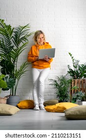 Woman girl using computer laptop working office work remotely from home. urban jungle home plants. Distance learning online education and work. 