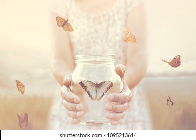 woman gives freedom to some butterflies enclosed in a glass vase - Shutterstock ID 1095213614