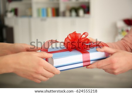 Woman giving books with ribbon as gift